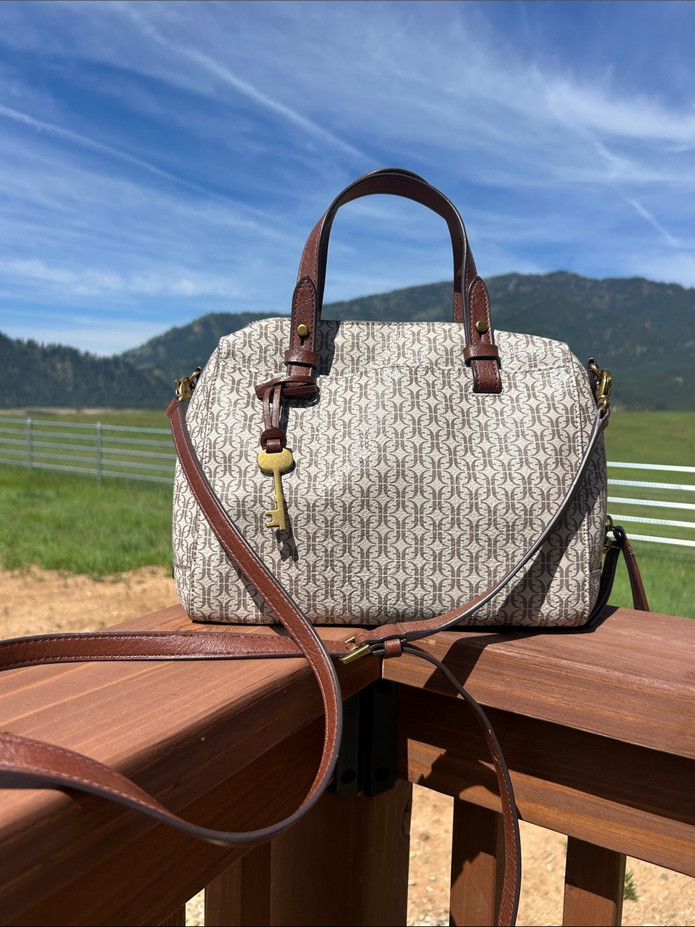 Fossil Rachel Satchel with a signature logo pattern, tan trim, and  key charm.